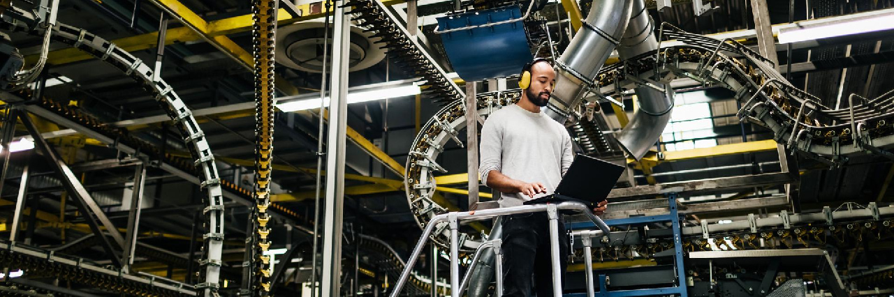 man using laptop in front of a huge machine accounts receivable insurance