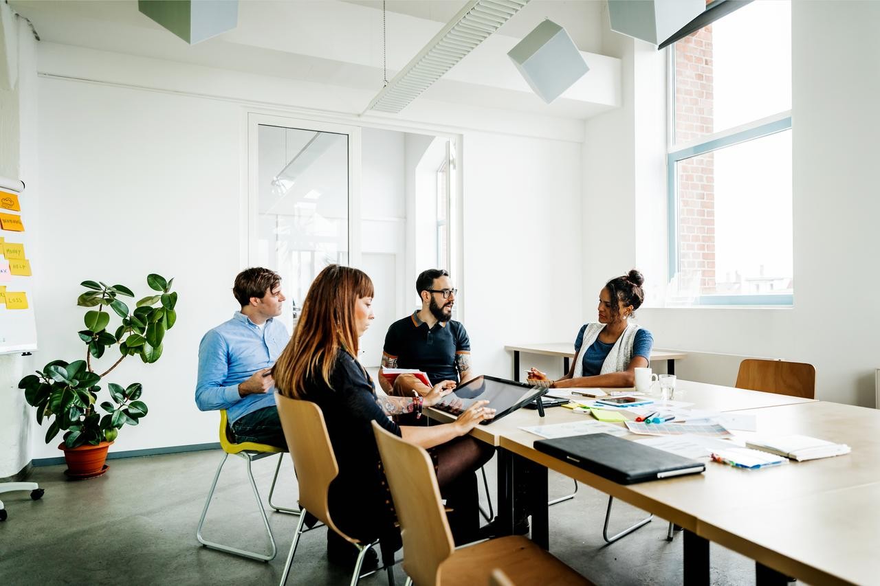 four people around a tabledoing a meeting